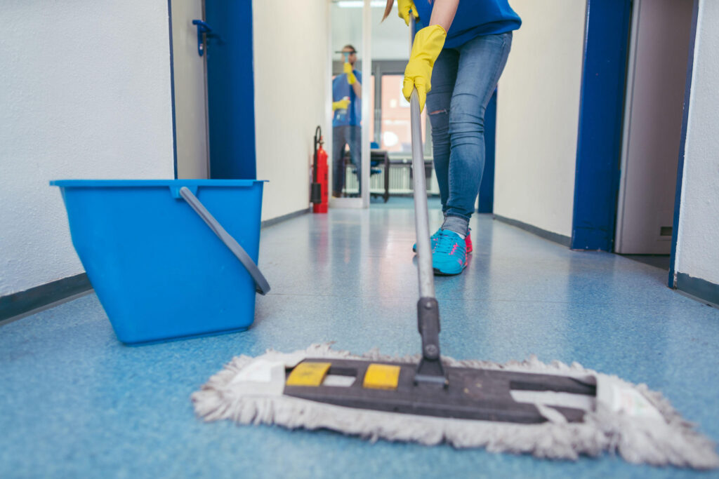 close up of cleaners moping the floor of a hall
